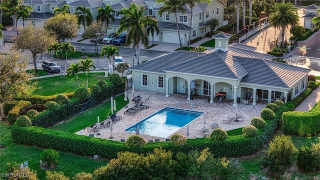 back of property with a fenced in pool, a patio, a tiled roof, and fence