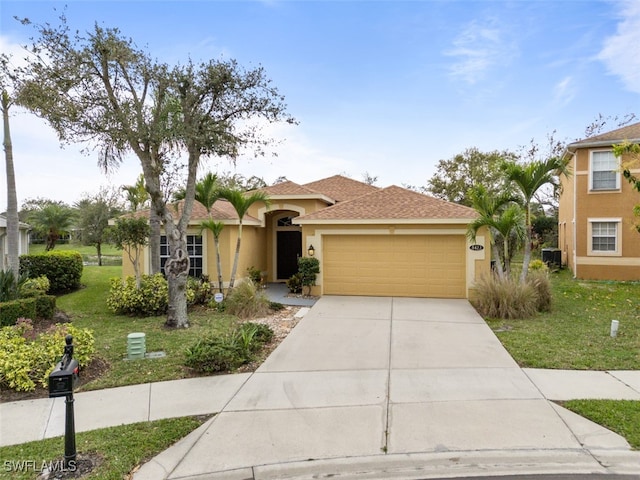 mediterranean / spanish-style house with a garage, concrete driveway, roof with shingles, stucco siding, and a front yard