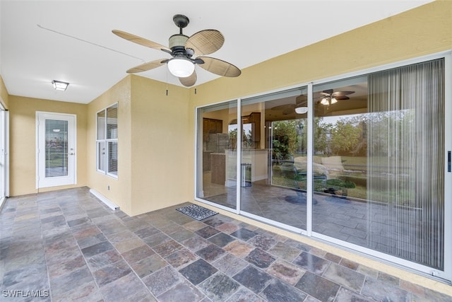 unfurnished sunroom with ceiling fan