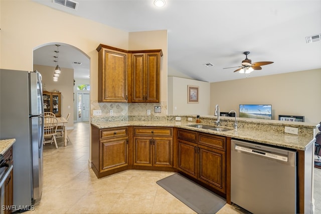 kitchen with appliances with stainless steel finishes, a sink, visible vents, and brown cabinets