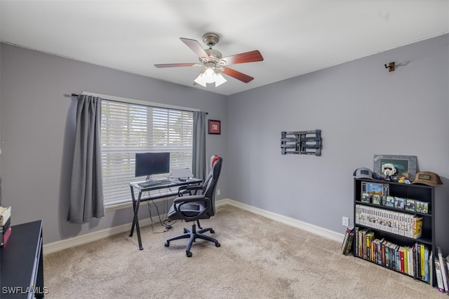 carpeted office featuring a ceiling fan and baseboards