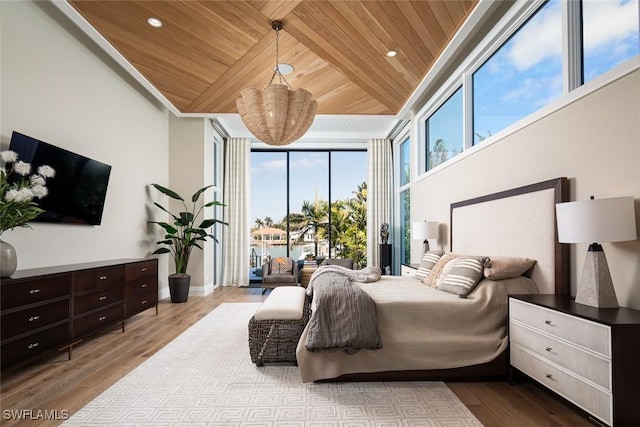 bedroom with wood finished floors, recessed lighting, access to exterior, floor to ceiling windows, and wooden ceiling