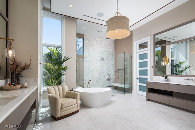 bathroom with vanity, a shower stall, a soaking tub, and visible vents