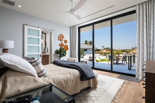 bedroom featuring visible vents, a wall of windows, recessed lighting, wood finished floors, and access to outside