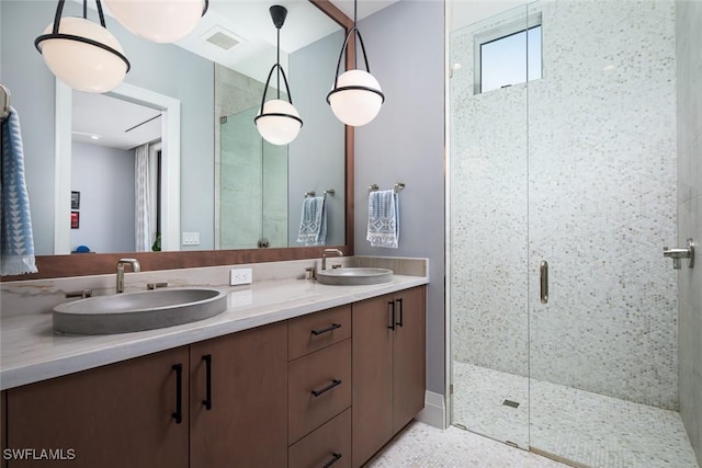 full bath with double vanity, visible vents, a stall shower, and a sink