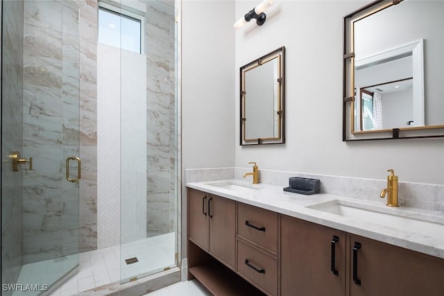 bathroom with double vanity, a stall shower, and a sink