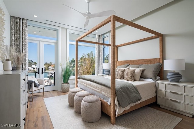 bedroom with multiple windows, light wood-style flooring, and floor to ceiling windows