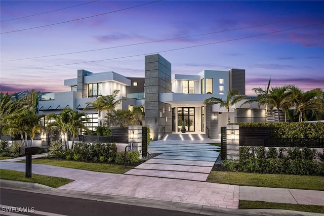 contemporary home with a fenced front yard and stucco siding