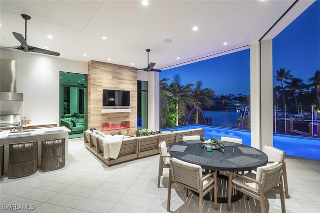 view of patio with an outdoor hangout area, outdoor dining area, an outdoor pool, a ceiling fan, and a sink