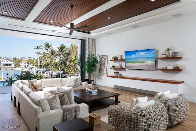 living area featuring a ceiling fan, wood finished floors, visible vents, a tray ceiling, and wood ceiling