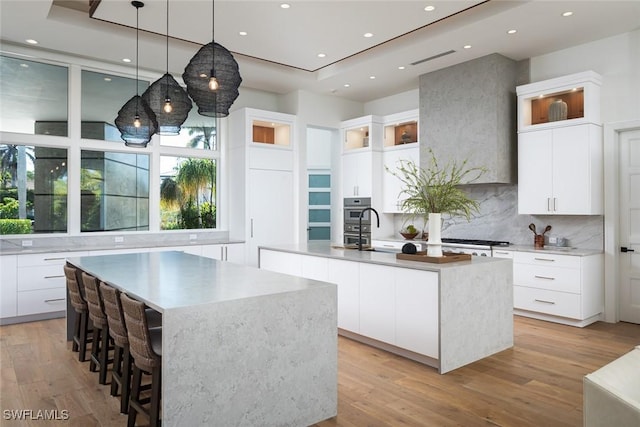 kitchen with modern cabinets, a center island with sink, and light wood-type flooring