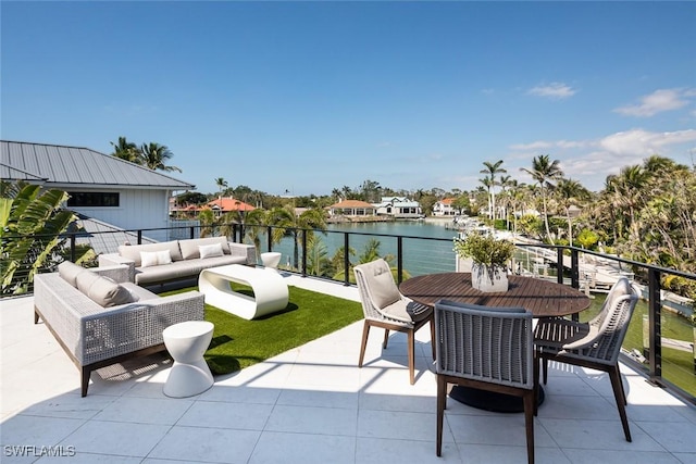 view of patio with an outdoor living space, a balcony, and a water view