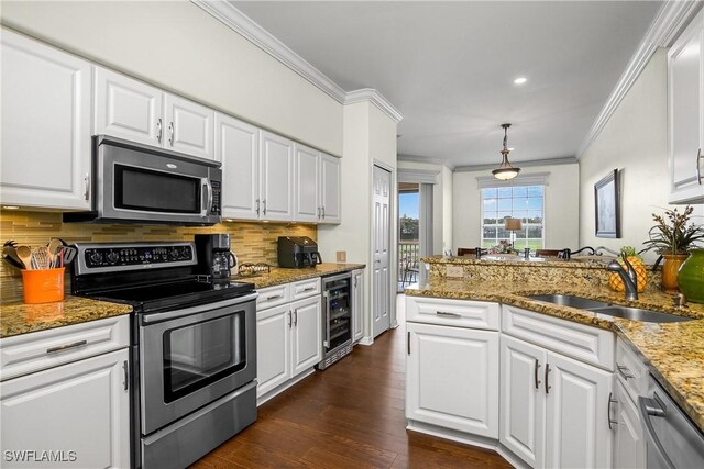 22810 Sago Pointe Dr Unit 2403, Estero, FL 34135 - kitchen featuring appliances with stainless steel finishes, beverage cooler, a sink, crown molding, and backsplash