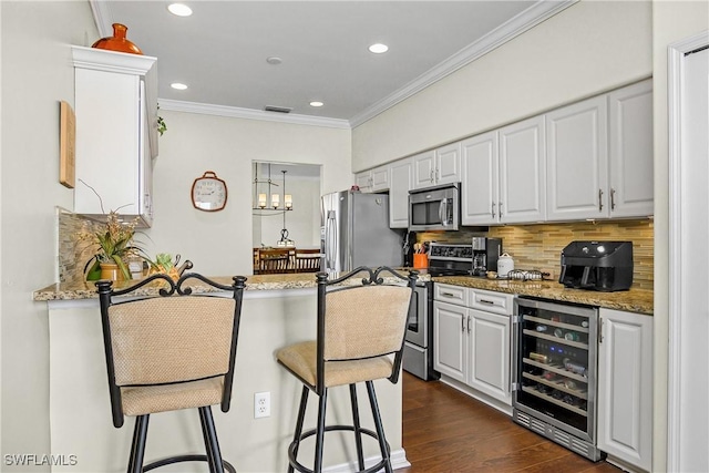 22810 Sago Pointe Dr Unit 2403, Estero, FL 34135 - kitchen with appliances with stainless steel finishes, wine cooler, backsplash, a kitchen bar, and light stone countertops