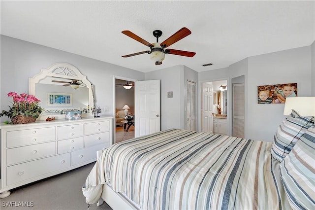 carpeted bedroom featuring ceiling fan, connected bathroom, and visible vents