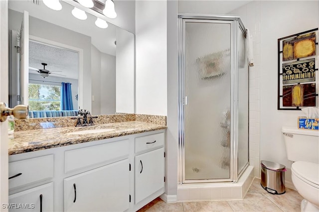 full bathroom featuring toilet, a textured ceiling, a shower stall, vanity, and tile patterned floors