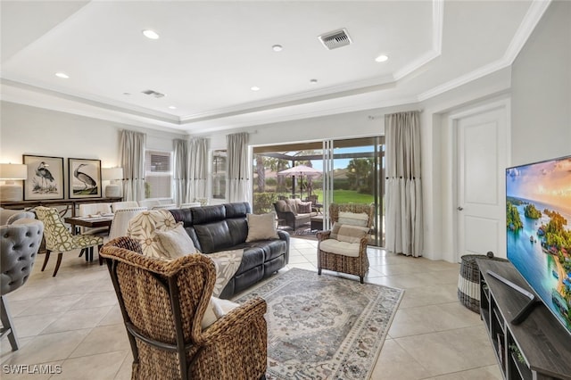 living area featuring light tile patterned floors, a tray ceiling, visible vents, and crown molding