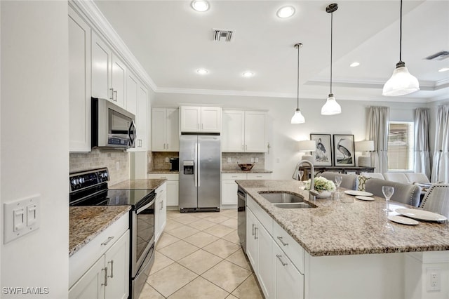 kitchen with stainless steel appliances, an island with sink, a sink, and white cabinetry