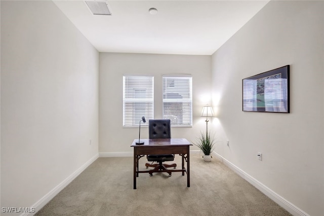 office area featuring baseboards, visible vents, and light colored carpet