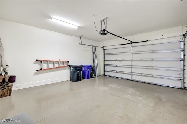 garage with baseboards and a garage door opener