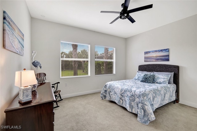 bedroom with light carpet, baseboards, and a ceiling fan