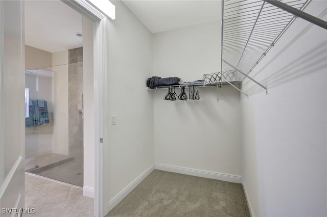 spacious closet with light carpet and light tile patterned floors