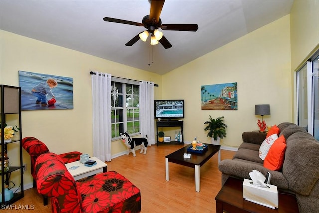 living area with vaulted ceiling, ceiling fan, light wood-type flooring, and baseboards