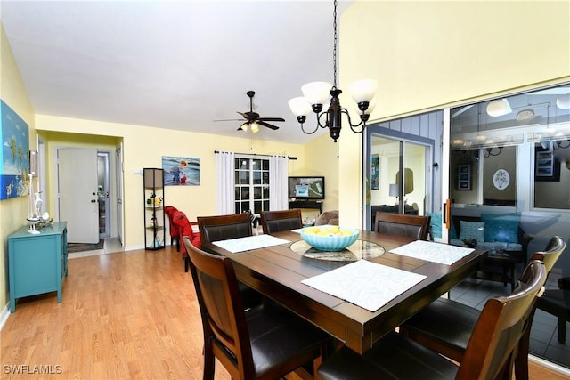 dining area featuring light wood finished floors and ceiling fan with notable chandelier