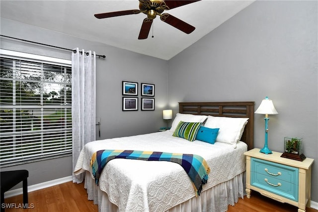 bedroom featuring vaulted ceiling, dark wood finished floors, a ceiling fan, and baseboards