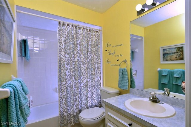 bathroom with shower / bath combo with shower curtain, vanity, and toilet