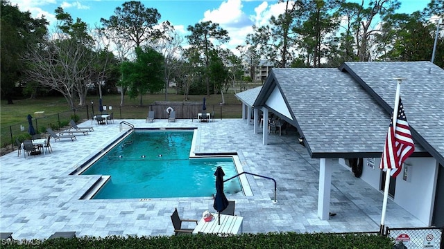 pool with a patio and fence