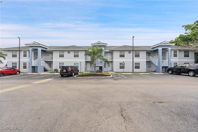 view of building exterior with a residential view and uncovered parking