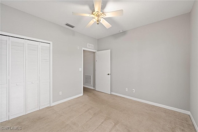 unfurnished bedroom featuring baseboards, visible vents, a closet, and light colored carpet