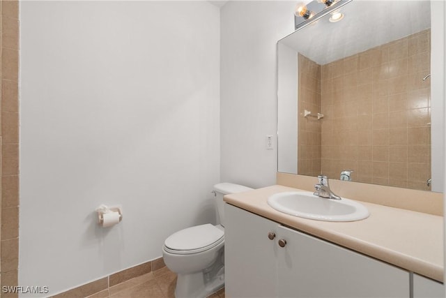 full bath with toilet, tile patterned flooring, baseboards, and vanity