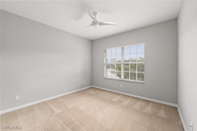 spare room featuring ceiling fan, carpet floors, and baseboards