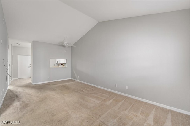 spare room featuring light carpet, ceiling fan, lofted ceiling, and baseboards