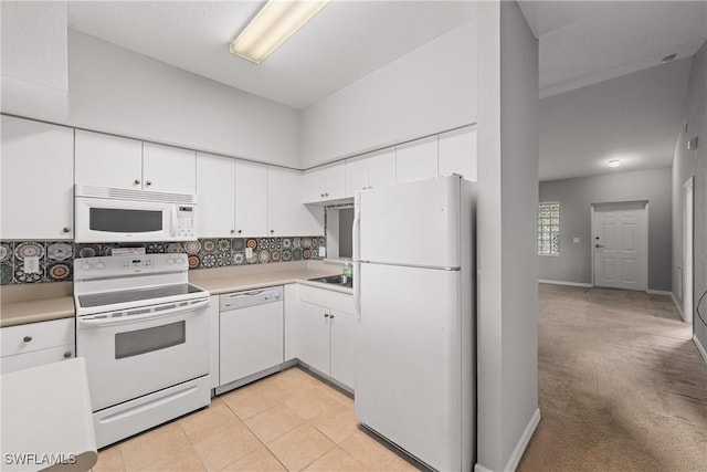 kitchen featuring light colored carpet, light countertops, decorative backsplash, white cabinetry, and white appliances