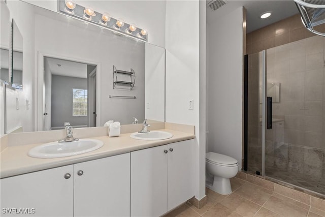 bathroom featuring double vanity, visible vents, toilet, and a sink