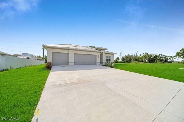 view of front of home featuring metal roof, an attached garage, a standing seam roof, fence, and a front yard