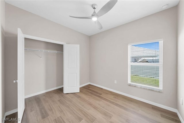 unfurnished bedroom with light wood-style flooring, baseboards, ceiling fan, and a closet