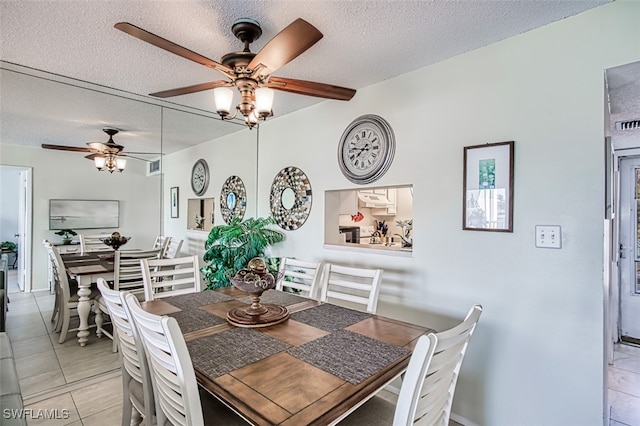 dining area with a textured ceiling and light tile patterned flooring