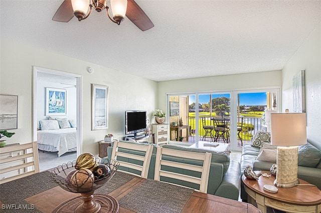 living area with a ceiling fan and a textured ceiling