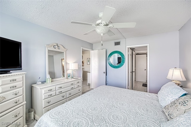 bedroom with a textured ceiling, ceiling fan, and visible vents