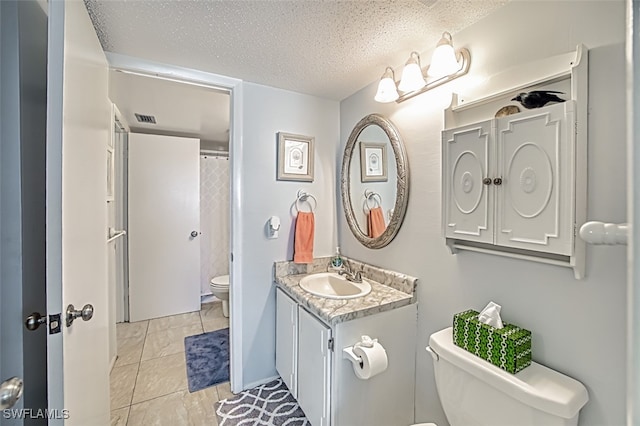 bathroom with visible vents, a textured ceiling, vanity, and toilet