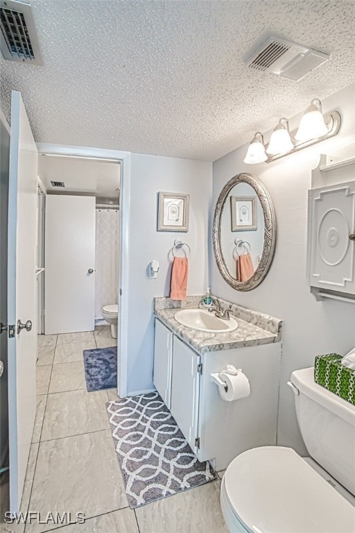 bathroom featuring toilet, a textured ceiling, vanity, and visible vents