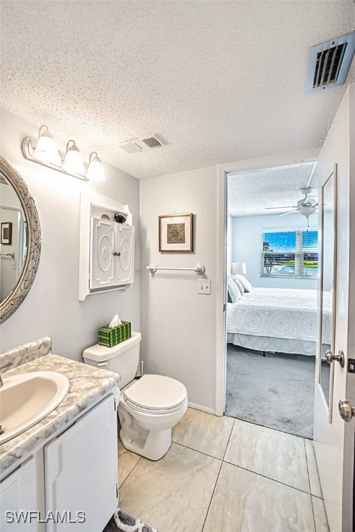 ensuite bathroom with toilet, visible vents, a textured ceiling, and ensuite bathroom