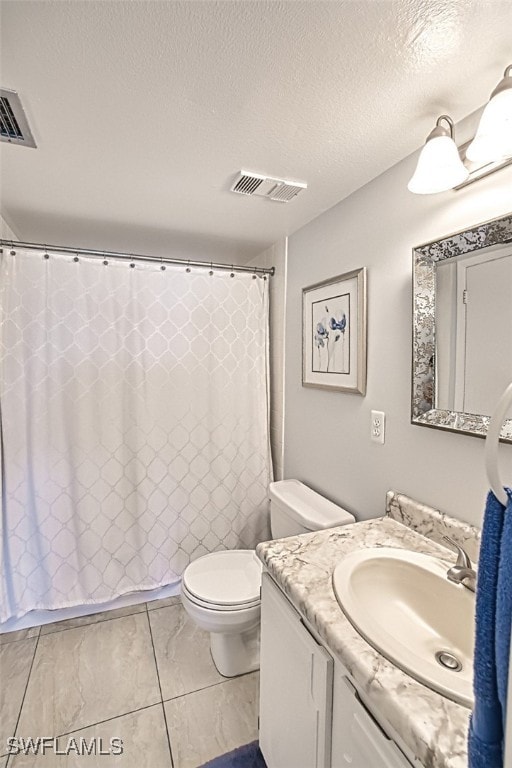 bathroom with visible vents, vanity, toilet, and a textured ceiling