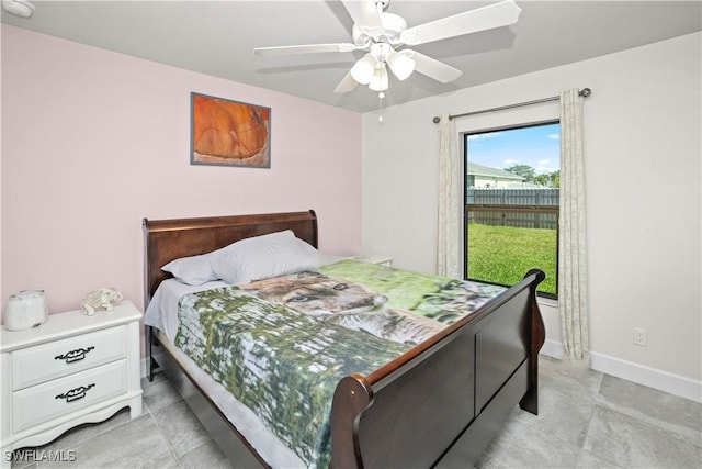 bedroom featuring ceiling fan, light tile patterned floors, and baseboards