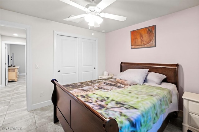 bedroom with ceiling fan, baseboards, a closet, and light tile patterned flooring