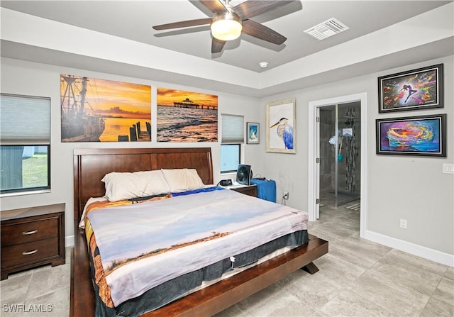 bedroom with a raised ceiling, visible vents, a ceiling fan, connected bathroom, and baseboards